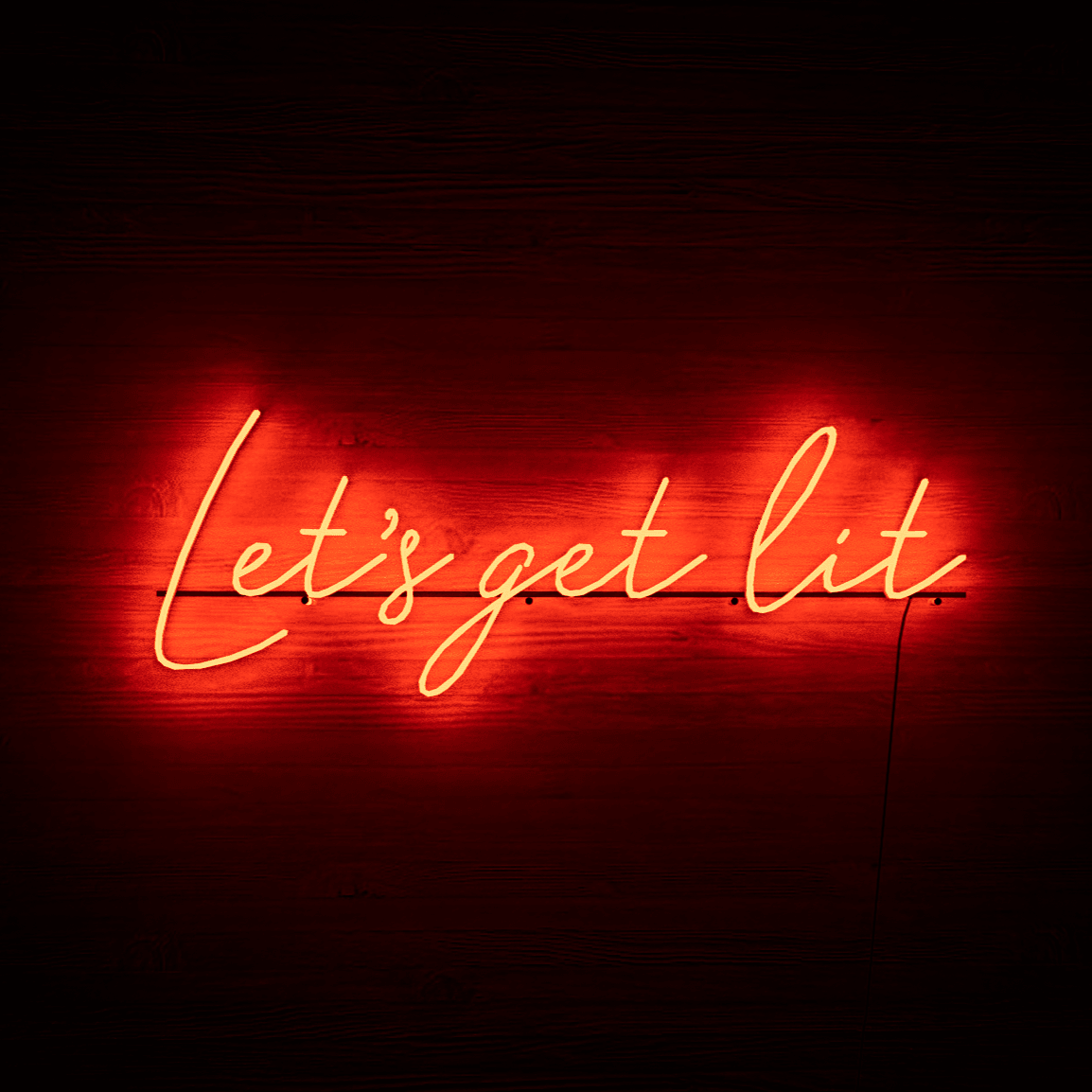 lit-red-neon-lights-hanging-on-the-wall-at-night-let's-get-lit