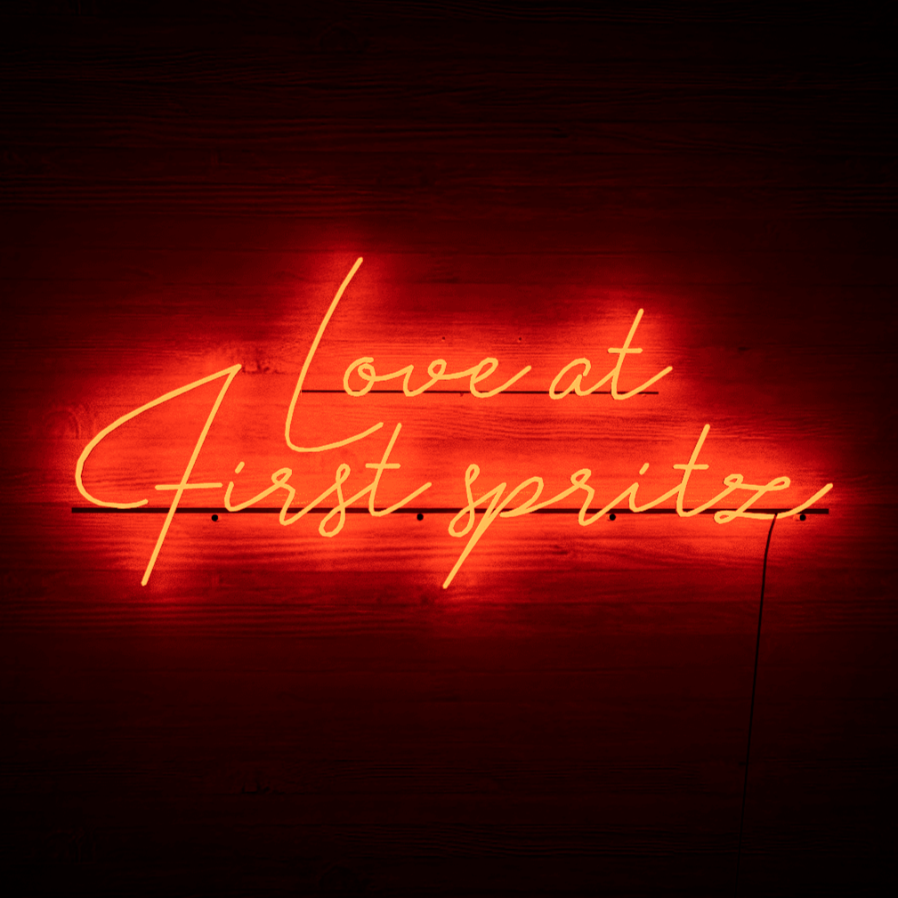 dark-night-lit-red-neon-lights-hanging-on-the-wall-for-display-love-at-first-spritz