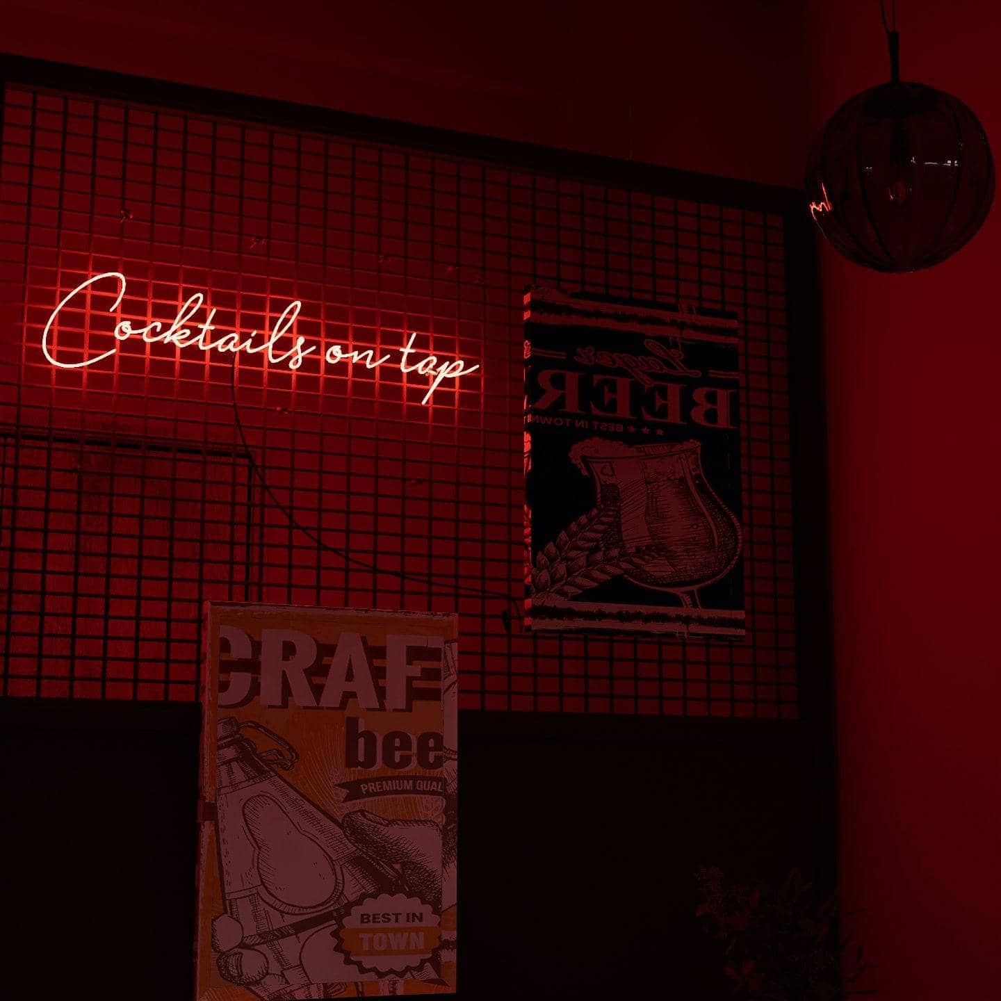 frontal-shot-of-lit-red-neon-lights-hanging-on-the-wall-at-night-cocktails-on-tap