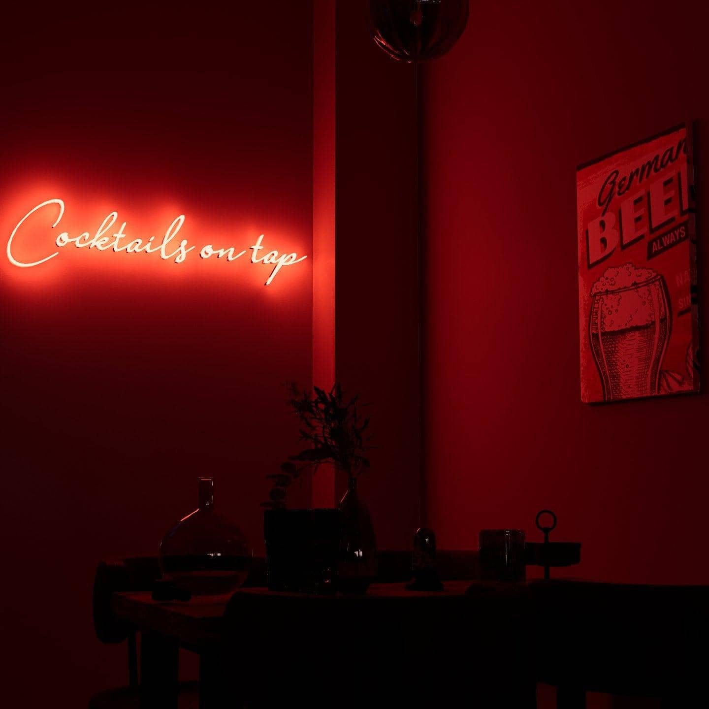 frontal-shot-of-lit-red-neon-lights-hanging-on-the-wall-at-night-cocktails-on-tap