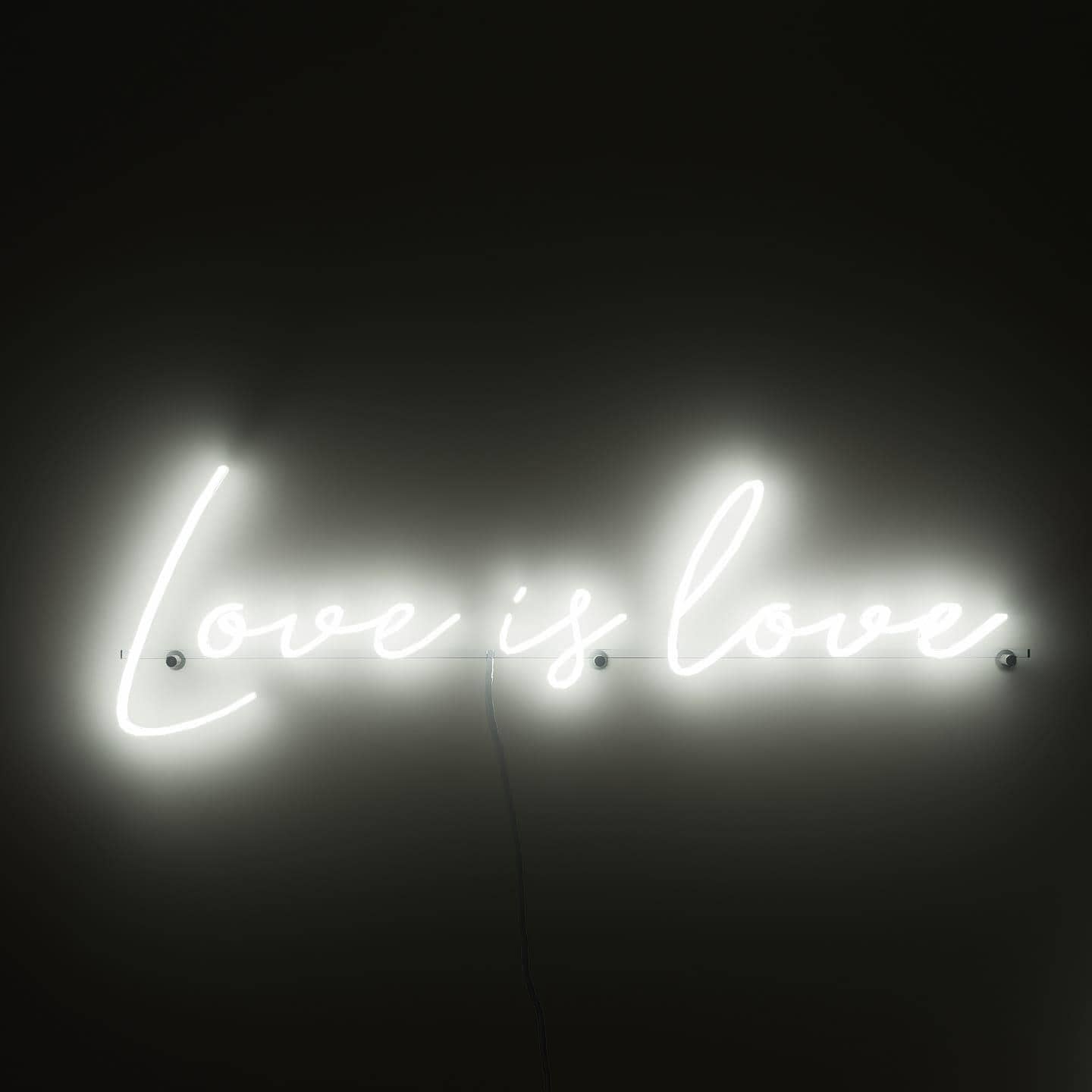 dark-night-shot-with-lit-white-neon-lights-hanging-on-the-wall-for-display-love-is-love