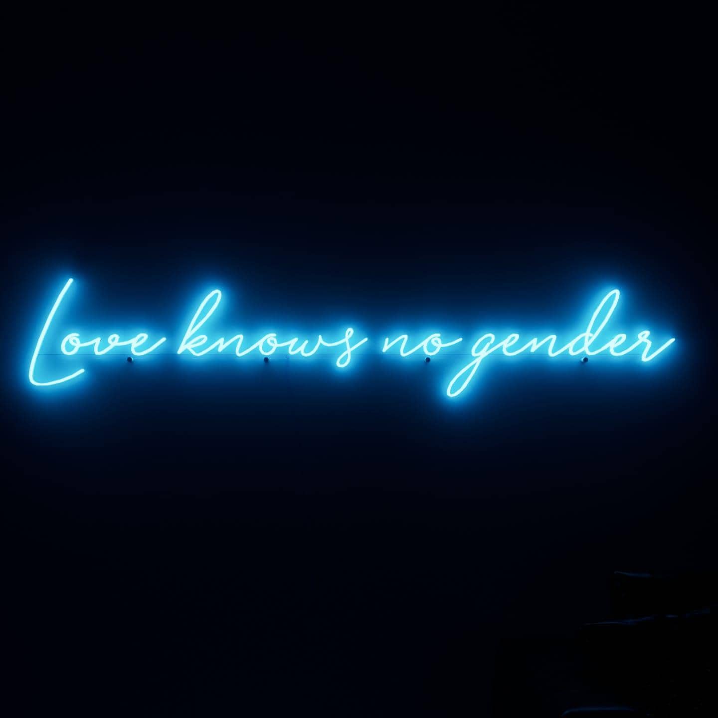 dark-night-shot-with-lit-blue-neon-lights-hanging-on-the-wall-for-display-love-knows-no-gender
